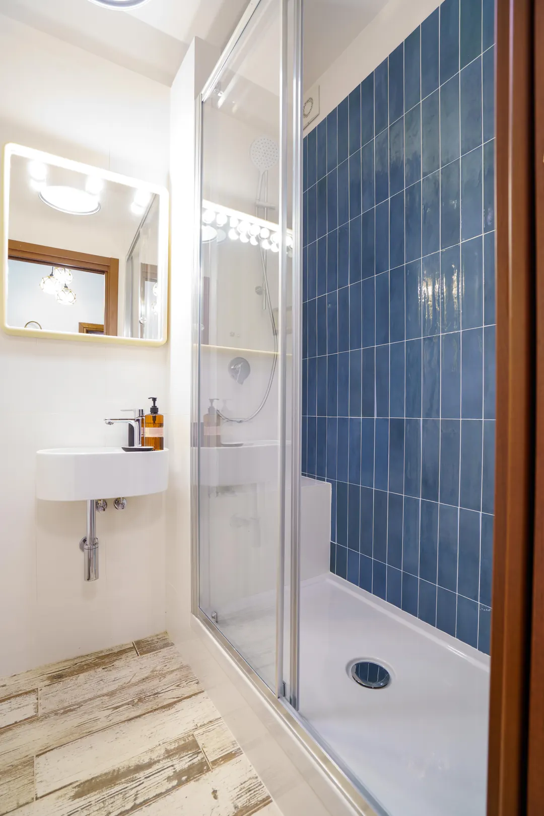 Secondo bagno con doccia rivestita di piastrelle blu